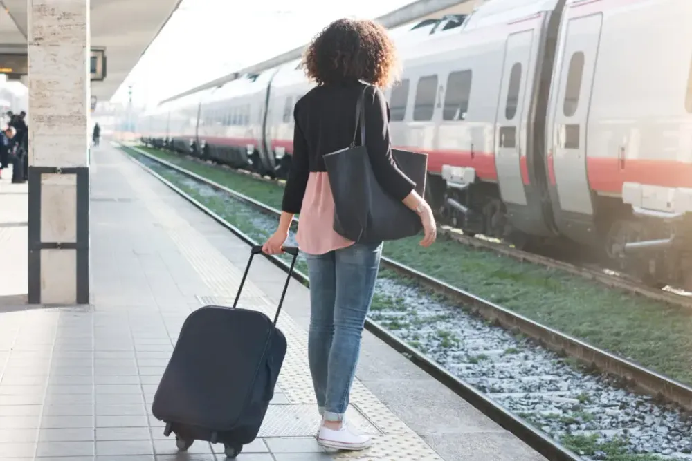 Woman waits for train with luggage